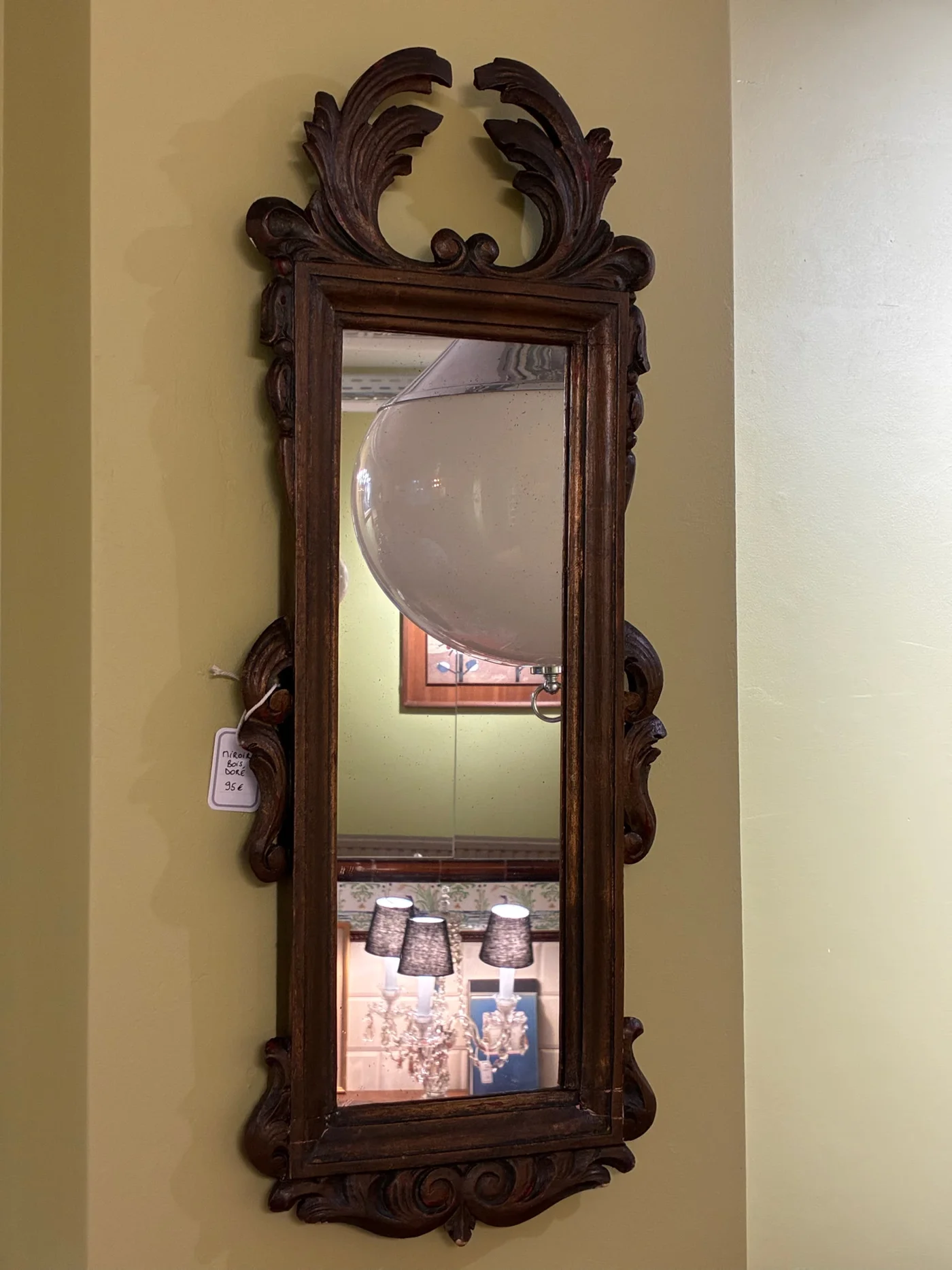Miroir en bois doré décoré de volutes d'acanthe et blason central, évoquant le style Louis XV ou Louis XVI - Ht 67 x 27cm