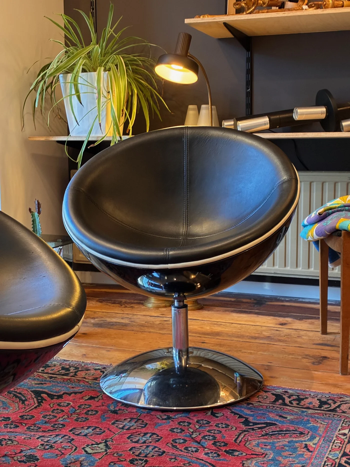 Paire de fauteuils "egg chair", pivotants, en similicuir noir, pied chromé - 1950s