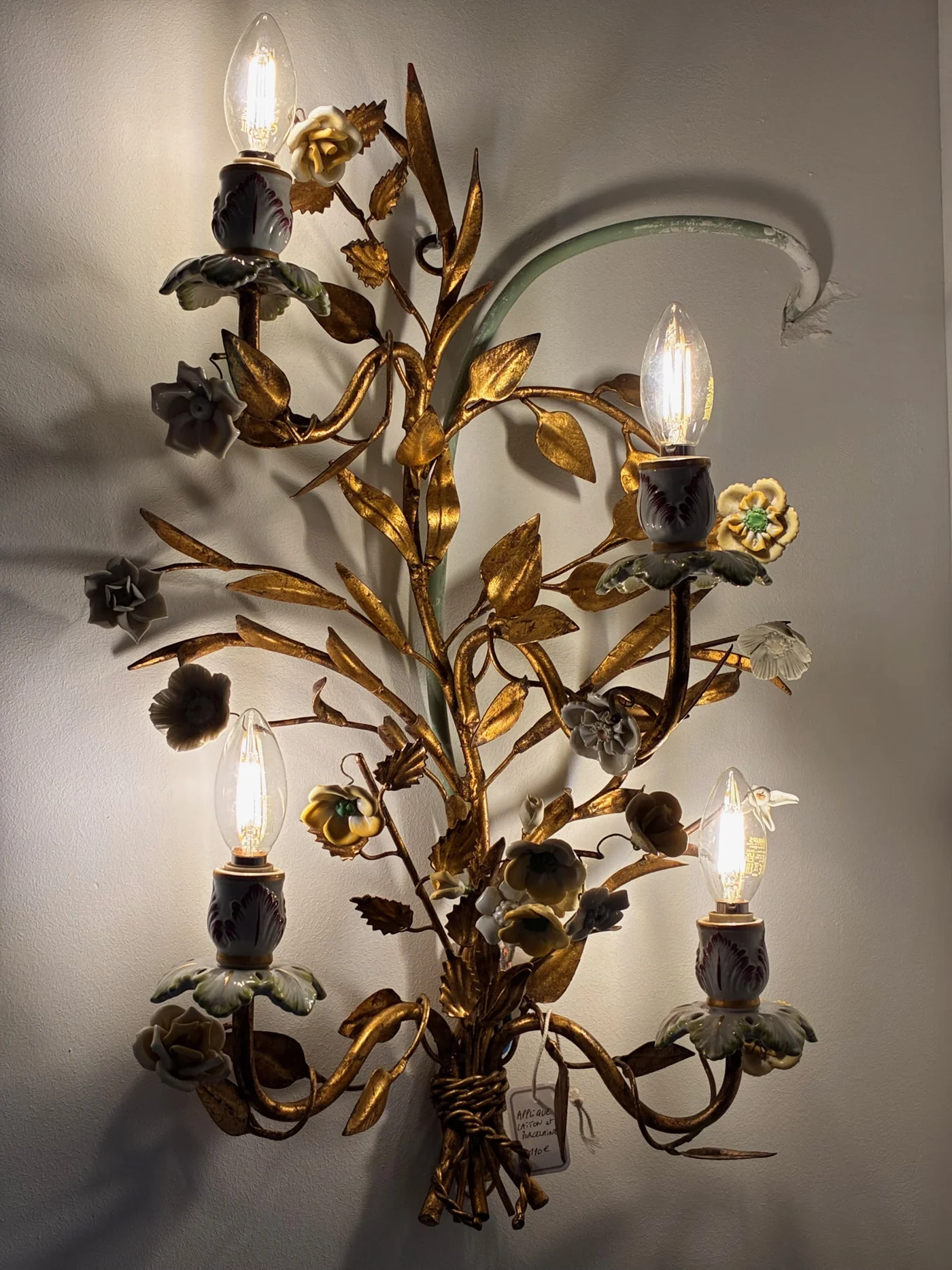 Applique en laiton doré et porcelaine à décor de fleurs, à quatre feux - Ht 60 cm 